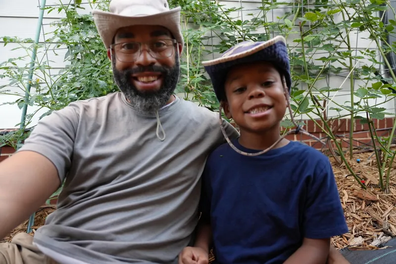 Steward Clinton e seu filho juntos entre as plantas